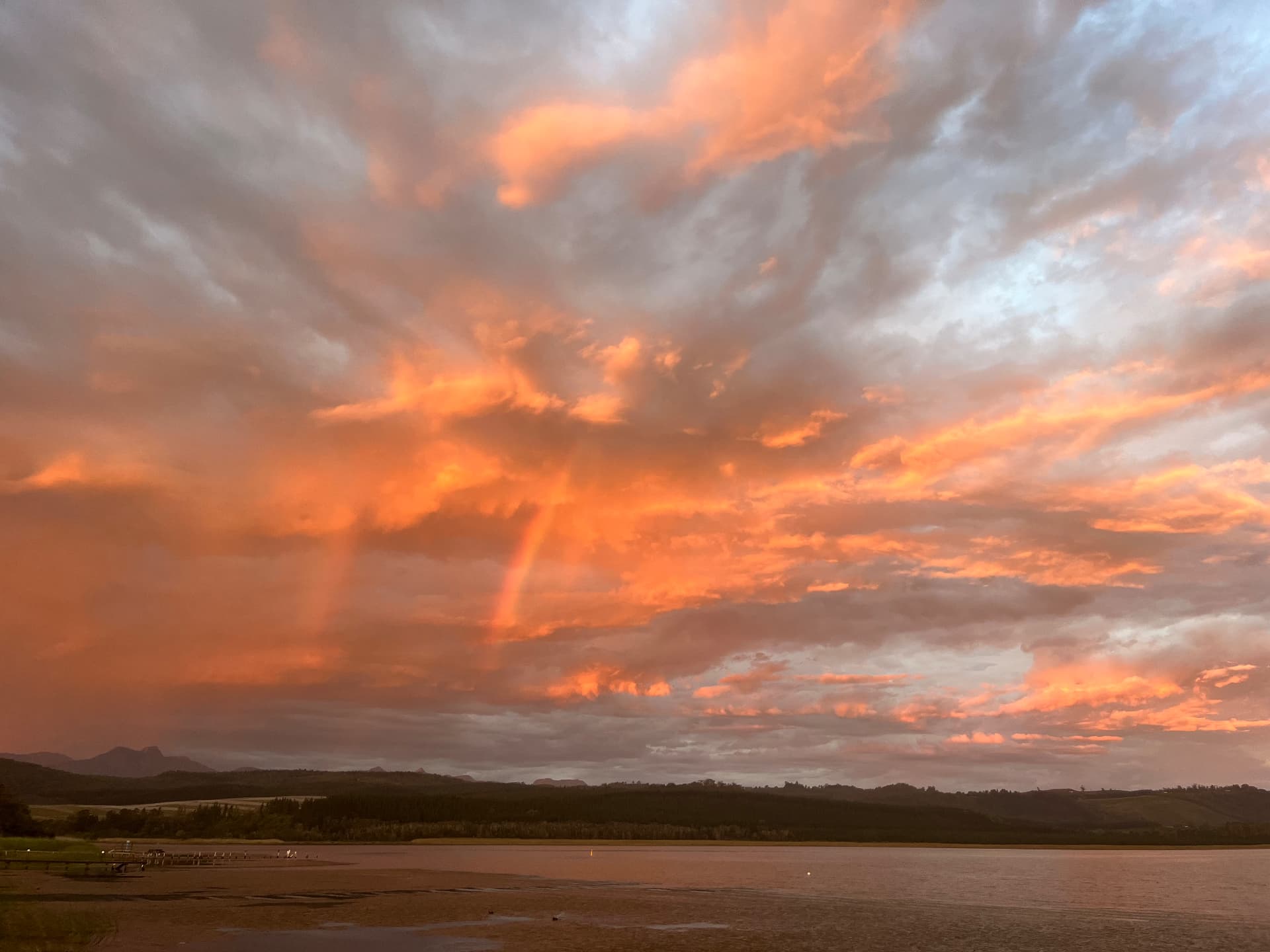 Dramatic orange sunset sky over the lake and mountains