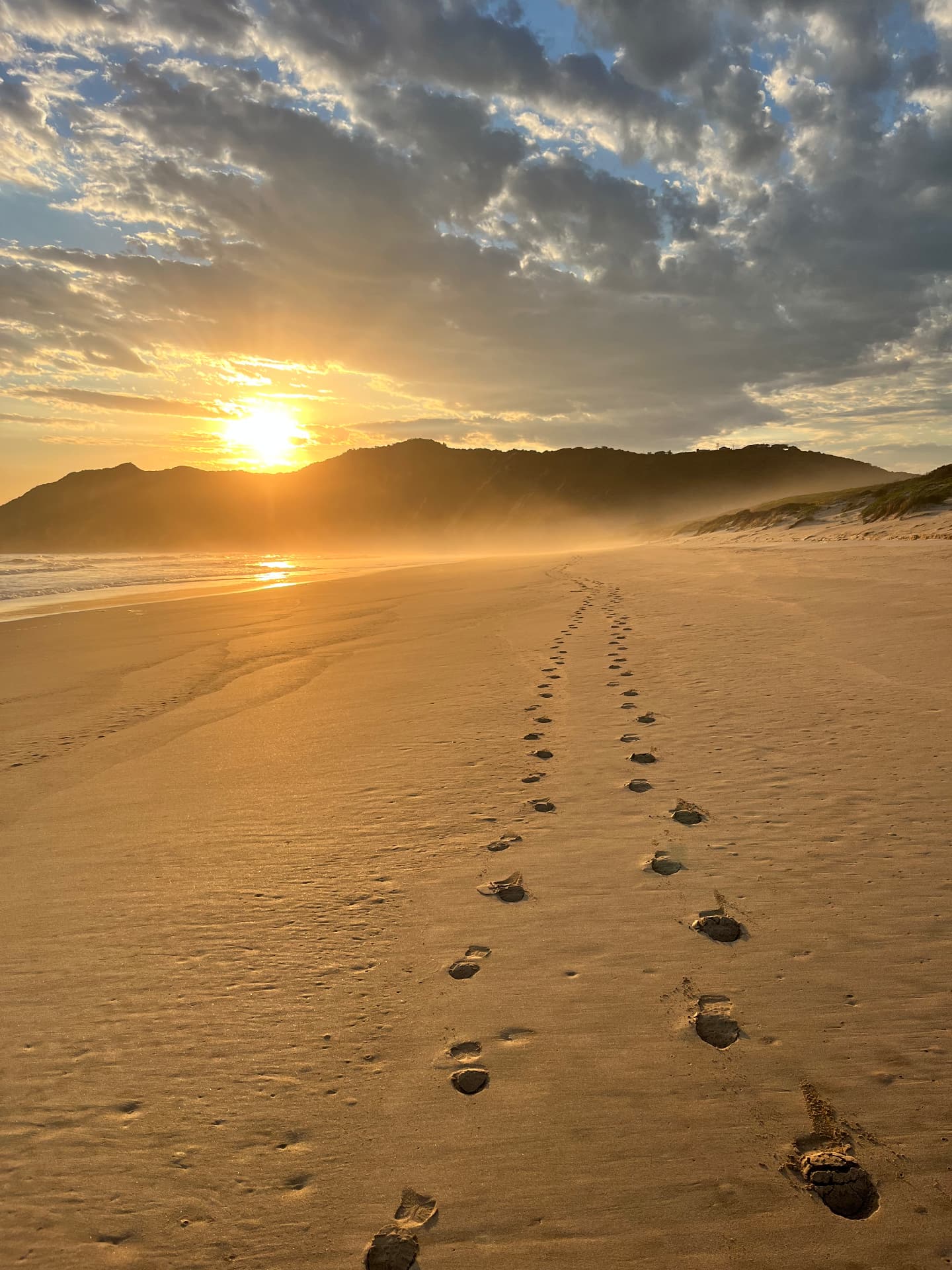 Footprints along a wide beach at sunrise on the Garden Route