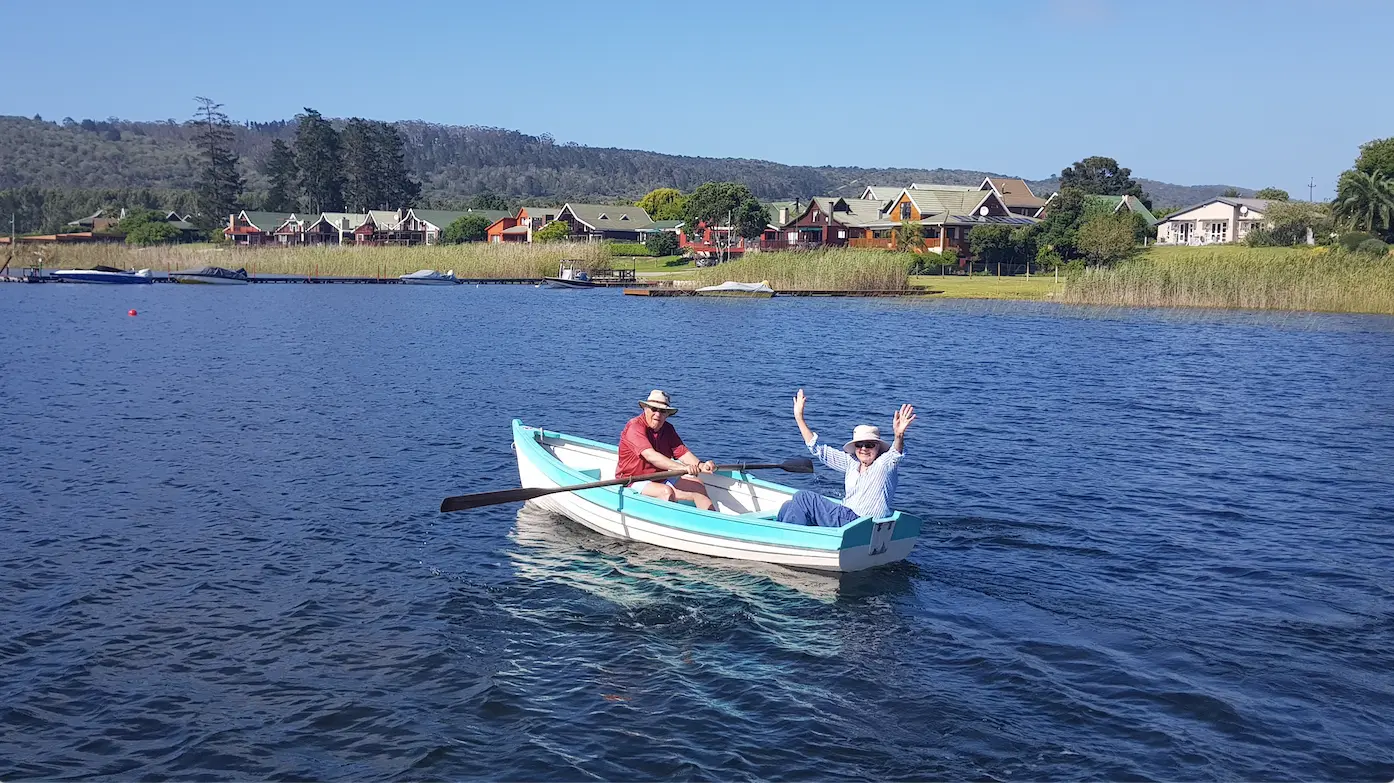 Guests rowing a wooden boat on Swartvlei Lake
