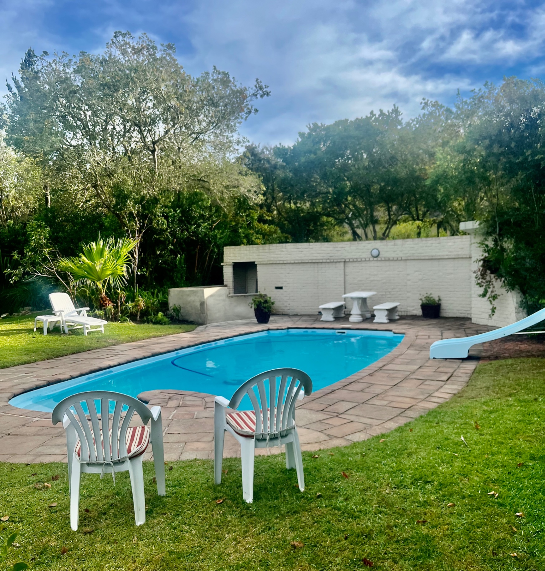 Estate swimming pool with sun loungers and braai area